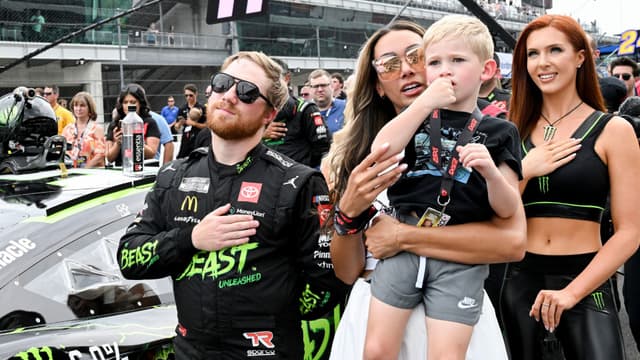NASCAR Cup Series driver Tyler Reddick (45) stands with his wife, Alexa De Leon, and son, Beau, during the national anthem ahead of the Brickyard 400, Sunday, July 21, 2024, at Indianapolis Motor Speedway.