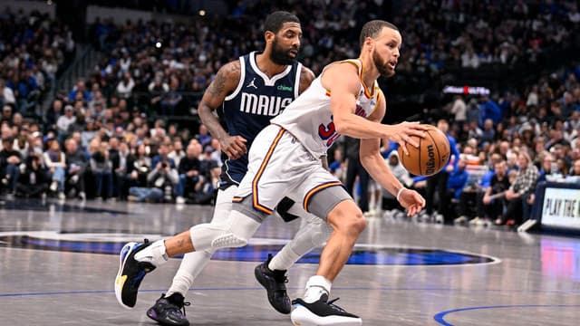 Golden State Warriors guard Stephen Curry (30) and Dallas Mavericks guard Kyrie Irving (11) in action during the game between the Dallas Mavericks and the Golden State Warriors at the American Airlines Center.