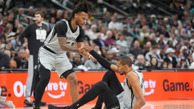San Antonio Spurs guard Stephon Castle (5) helps up forward Victor Wembanyama (1) in the first half against the Dallas Mavericks at Frost Bank Center