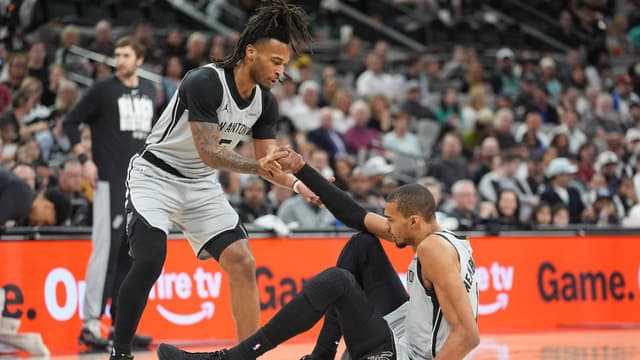 San Antonio Spurs guard Stephon Castle (5) helps up forward Victor Wembanyama (1) in the first half against the Dallas Mavericks at Frost Bank Center